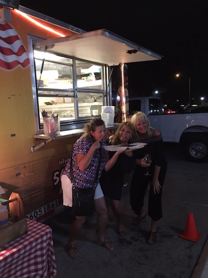 Happy guests showing off a plate of BBQ at night