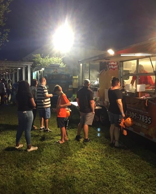 Guests lined up at the Yellowstone Prime BBQ trailer at an evening event